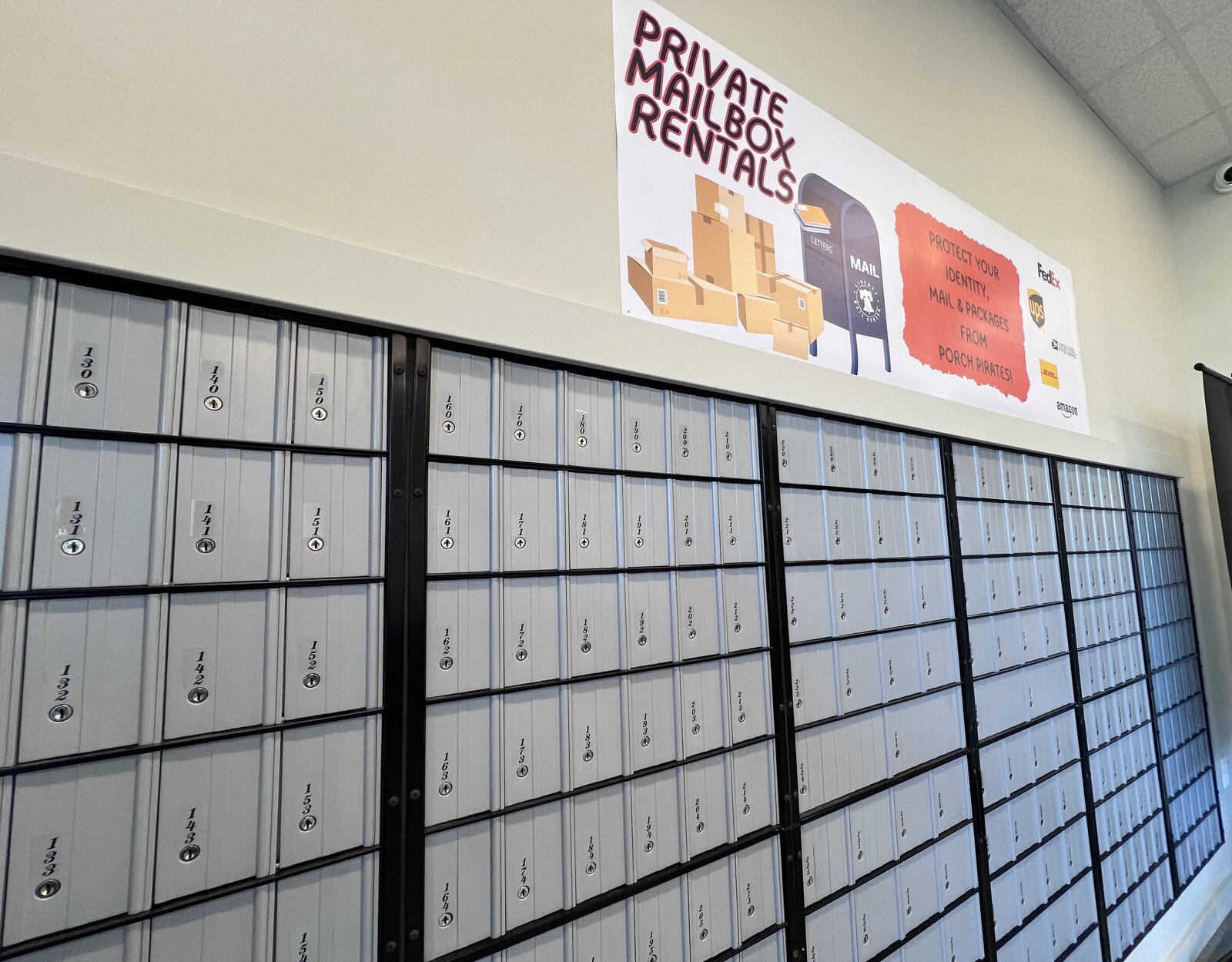 Wall of private mailboxes in the Liberty Mail Center lobby, with the Private Mailbox Rentals sign above