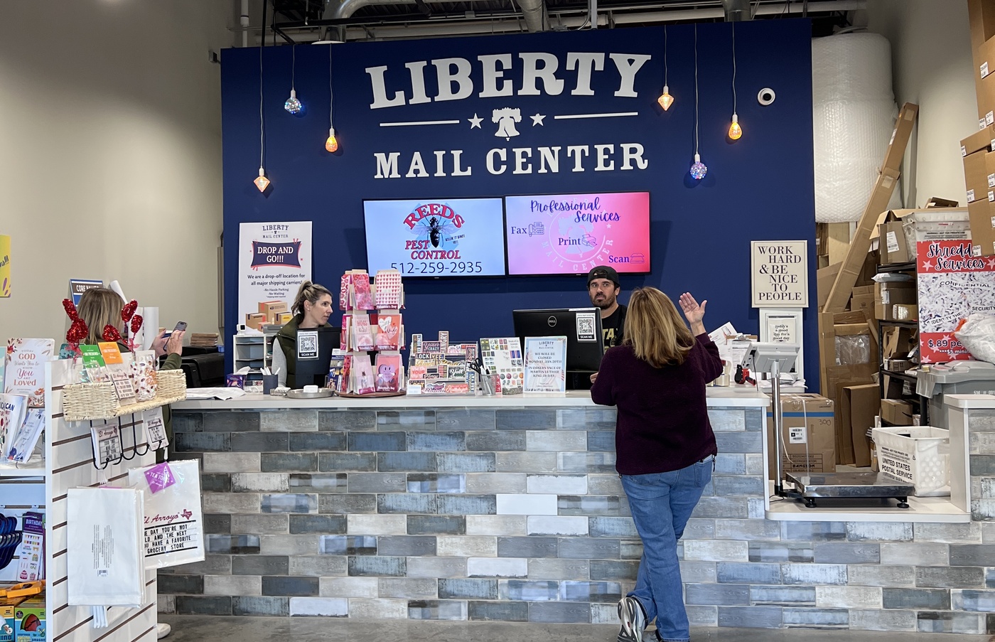 Interior of Liberty Mail Center showing the front counter and sign
